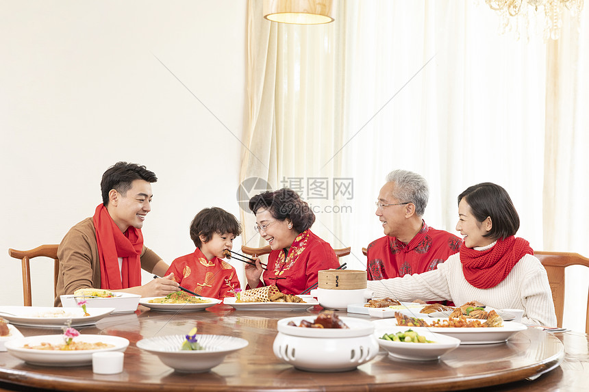 新春年夜饭奶奶夹菜喂小男孩图片