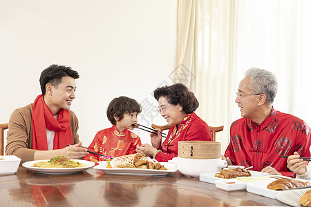 新春年夜饭奶奶夹菜喂小男孩图片