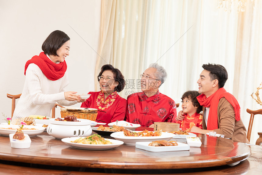 新春年夜饭团圆饭妈妈为长辈盛汤图片