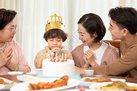 过生日的小朋友对着生日蛋糕许愿高清图片