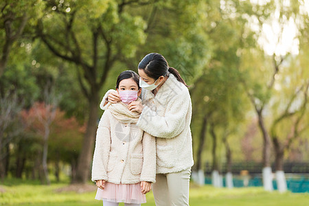 妈妈帮女儿调整口罩图片