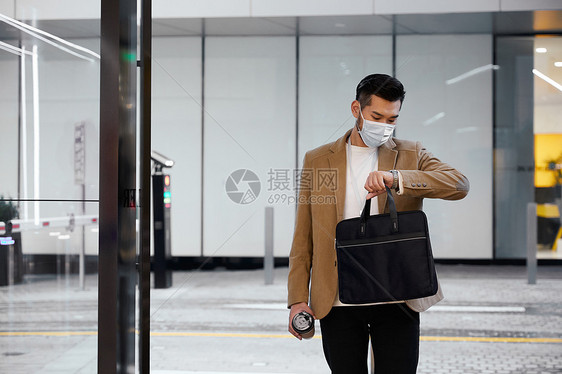 戴口罩看时间的白领男士图片