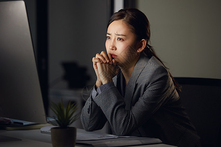 熬夜加班的白领看着电脑发呆苦恼背景图片