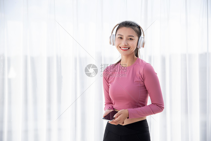 ‘~穿着运动装的年轻美丽的小姐姐在窗边戴耳机听音乐  ~’ 的图片