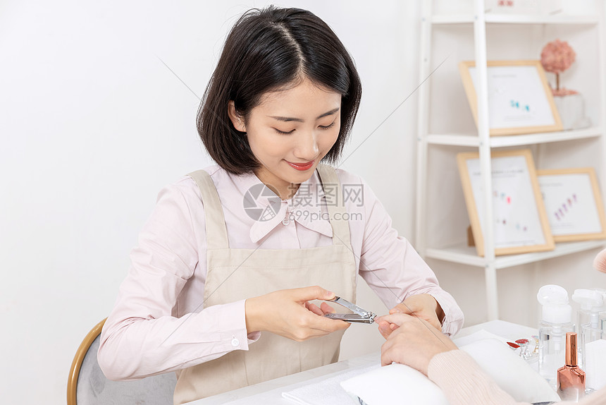 女性美甲师给顾客修剪指甲图片