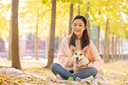 柯基犬女性抱着宠物坐在地上带宠物的人背景