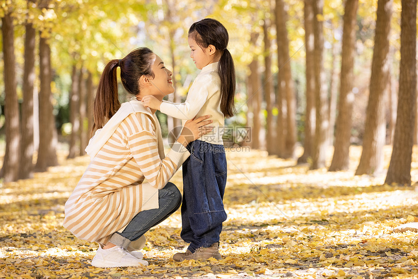 秋季温馨妈妈蹲下和女儿对视图片