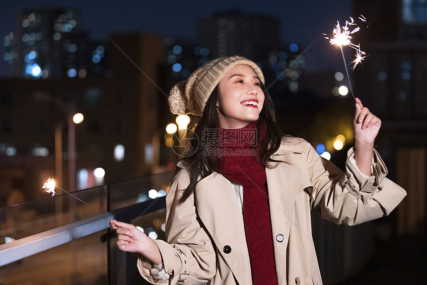 秋冬夜晚美女过圣诞节放烟花棒图片