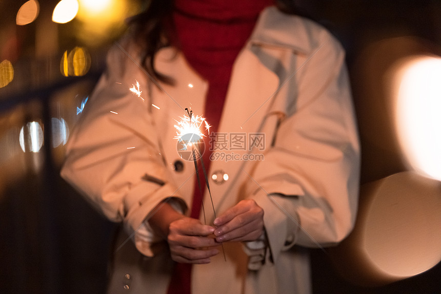 秋冬夜晚美女过圣诞节放烟花棒特写图片