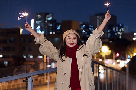 秋冬夜晚美女过圣诞节放烟花棒图片