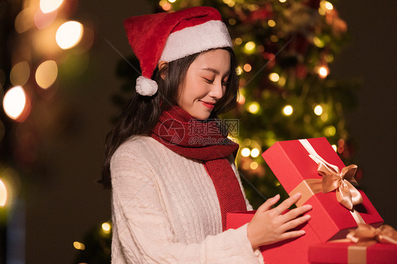 秋冬夜晚美女过圣诞节拆开礼物盒图片