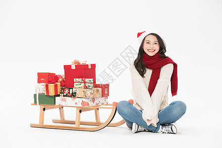 美女用圣诞雪橇载圣诞礼物图片