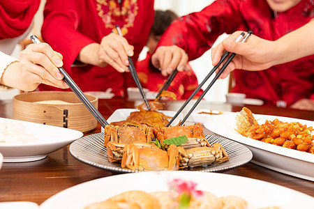 新春家庭团圆年夜饭夹菜吃大闸蟹特写图片