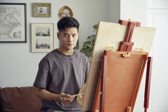 年轻男生在家创作油画图片