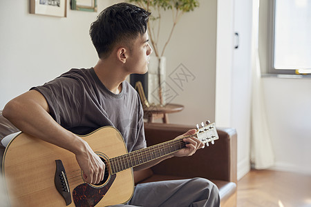 文艺男青年在家弹吉他图片