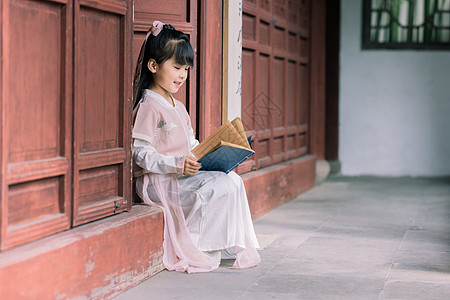蹲着的古风女孩古装汉服儿童公园里看书背景