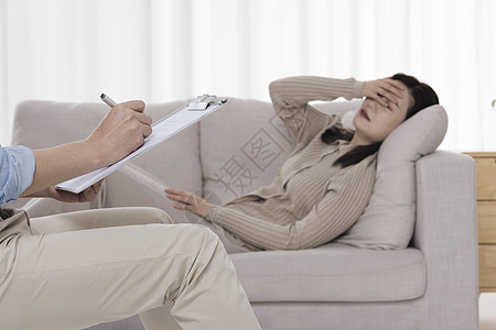 女性心理疾病患者难过的捂着脸躺在沙发上图片