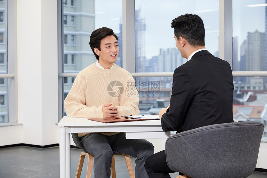 青年男性与房产销售签订合同图片