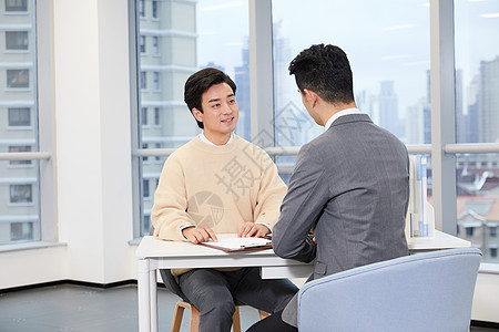 青年男性与房产销售签订合同图片