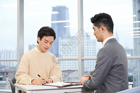 青年男性与房产销售签订合同背景图片