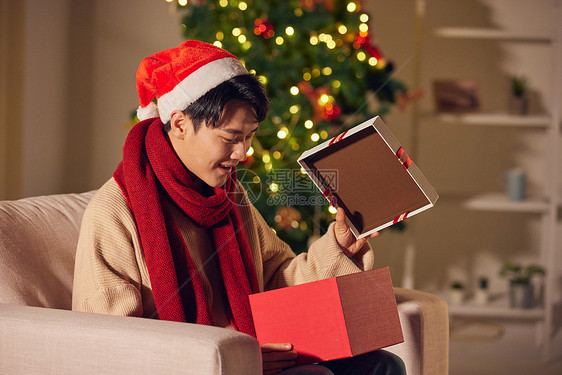 年轻男士圣诞节打开礼物盒惊喜表情图片