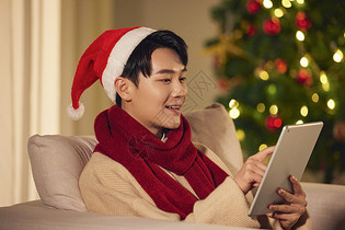 阳光男生圣诞节在家玩平板电脑图片