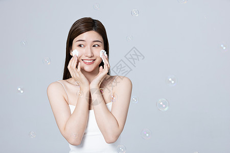 女性使用泡沫洗面奶清洁面部图片