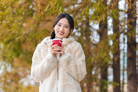 秋冬户外手捧咖啡的美女图片