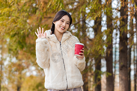 秋冬户外手捧咖啡的美女高清图片