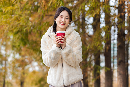 秋冬户外手捧咖啡的美女图片