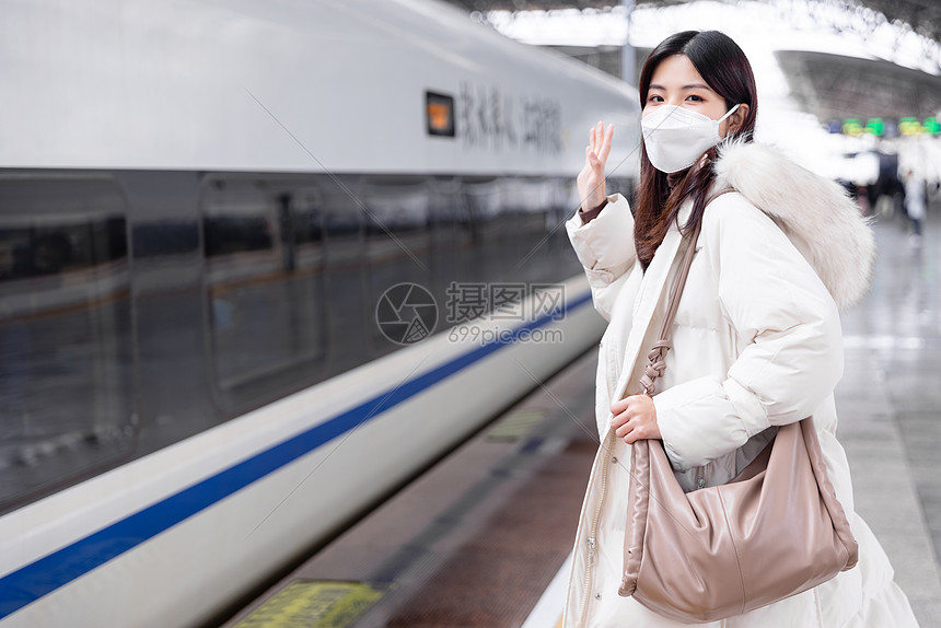 女性在火车站台挥手告别