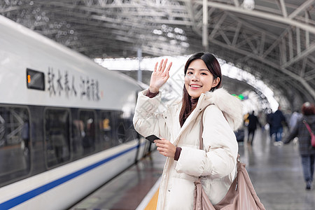 即将上列车返乡的女性挥手道别图片素材