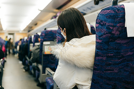 女性坐在火车车厢内四处张望图片