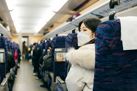 女性坐在火车车厢内四处张望图片