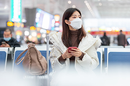 照片  |疫情时期在火车站戴口罩的女性春运回家照片  |在外使用笔记本