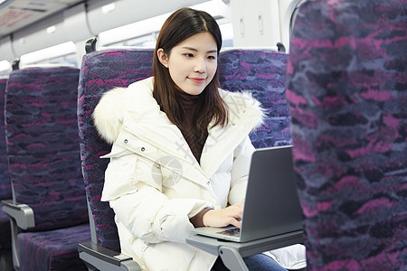 女生在火车上用笔记本电脑办公图片