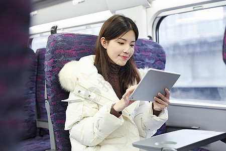 女生在火车上使用平板电脑图片