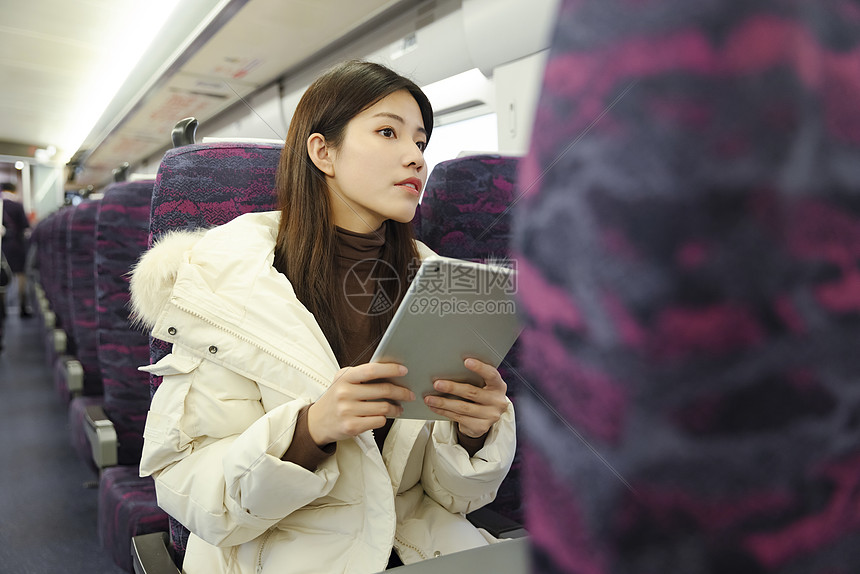 女生在地铁上使用平板电脑图片