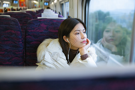 坐在火车上看车窗外思考的女性图片