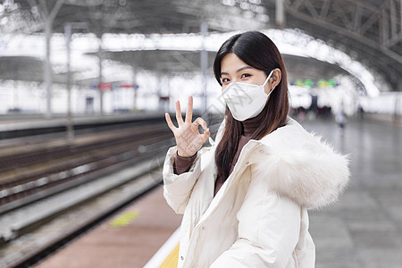 戴口罩的女性在列车站台比ok手势高清图片