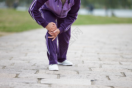 中国男人老奶奶逛公园腿部膝盖疼痛特写背景