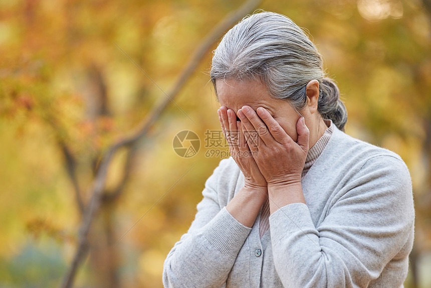 老年人老奶奶公园里痛苦捂住脸