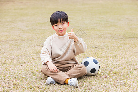 儿童看手机秋季小男孩公园草坪踢足球点赞背景