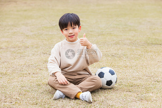 秋季小男孩公园草坪踢足球点赞图片