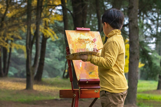 秋季儿童公园里拿调色盘绘画图片