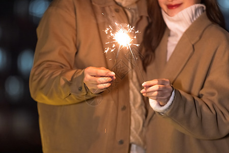 秋冬夜晚情侣室外放烟花特写图片