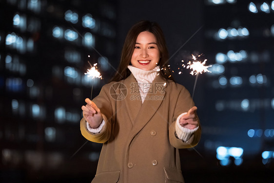 秋冬夜晚美女室外放烟花图片