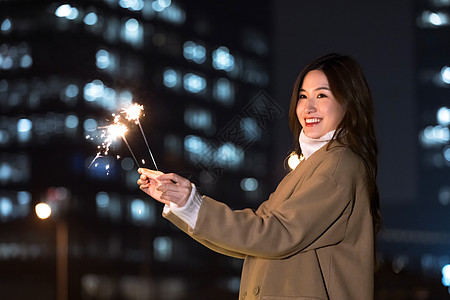 秋冬夜晚美女室外放烟花图片