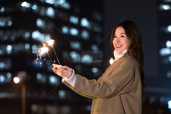 秋冬夜晚美女室外放烟花图片