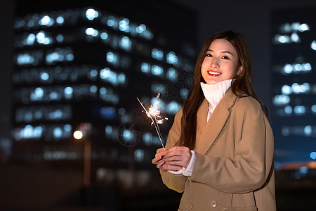 秋冬夜晚美女室外放烟花图片